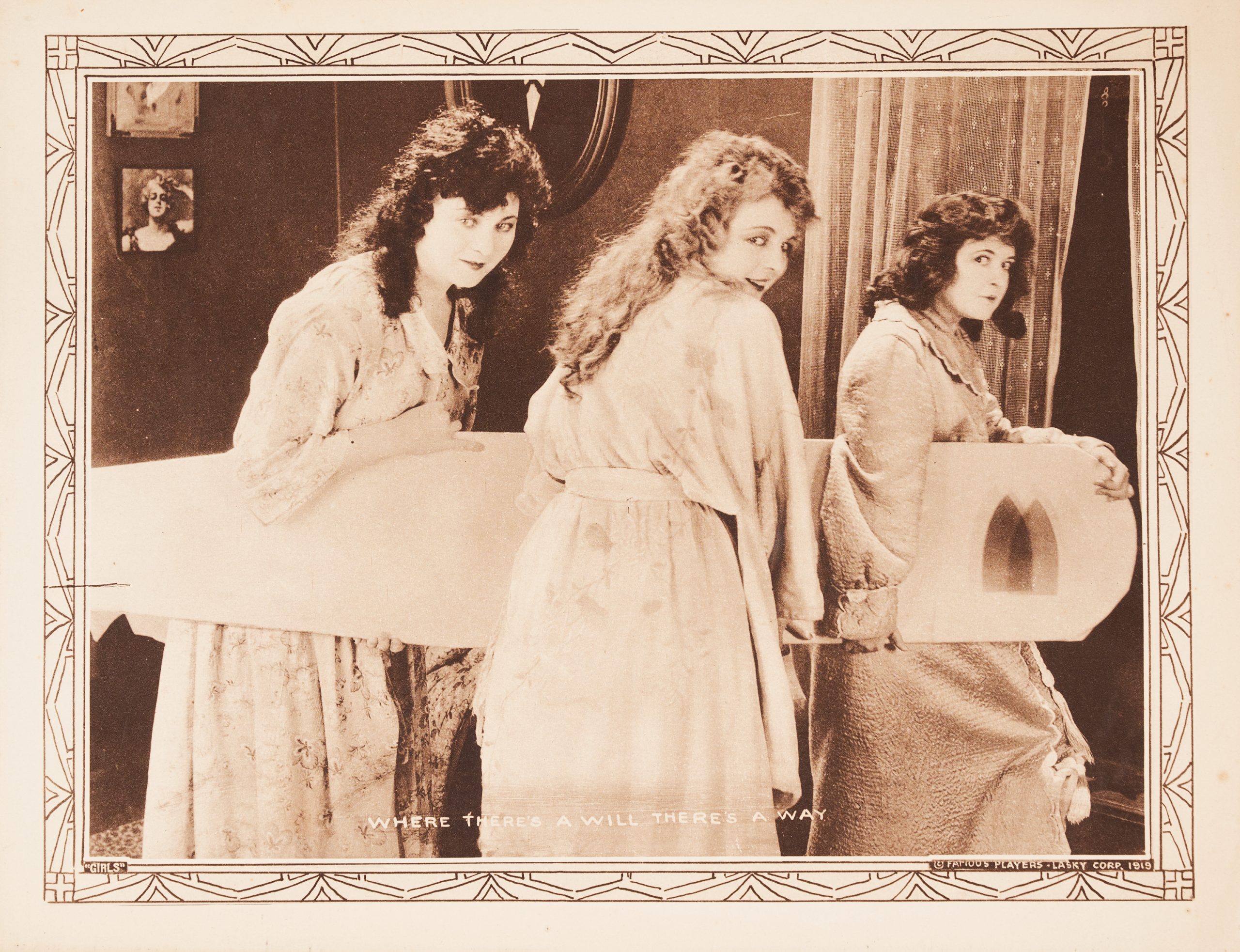 A lobby card showing three women carrying an iron board and looking at the viewer conspiratorially.