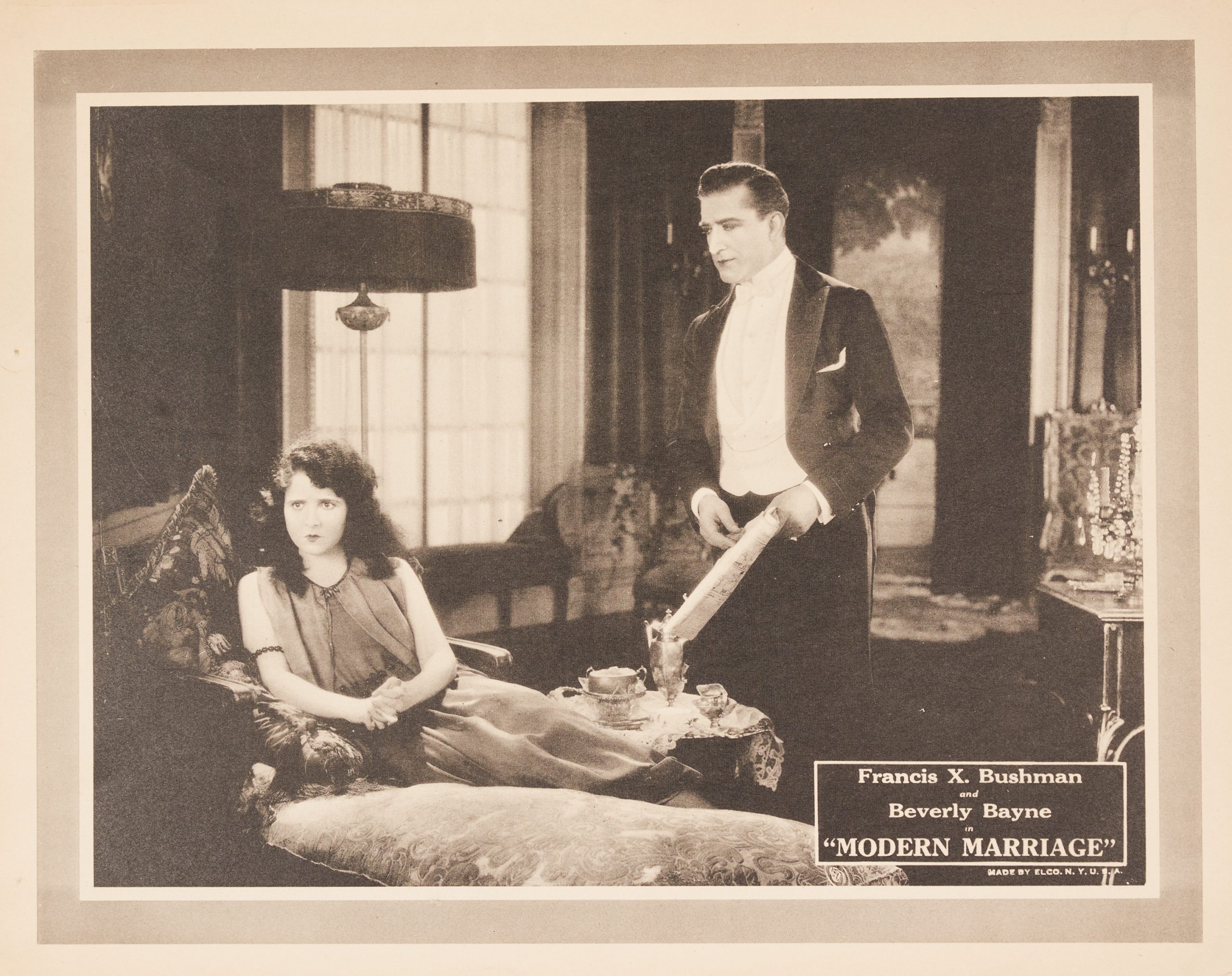 A lobby card showing a woman sitting, looking upset and gazing ahead, while a man looks over her.