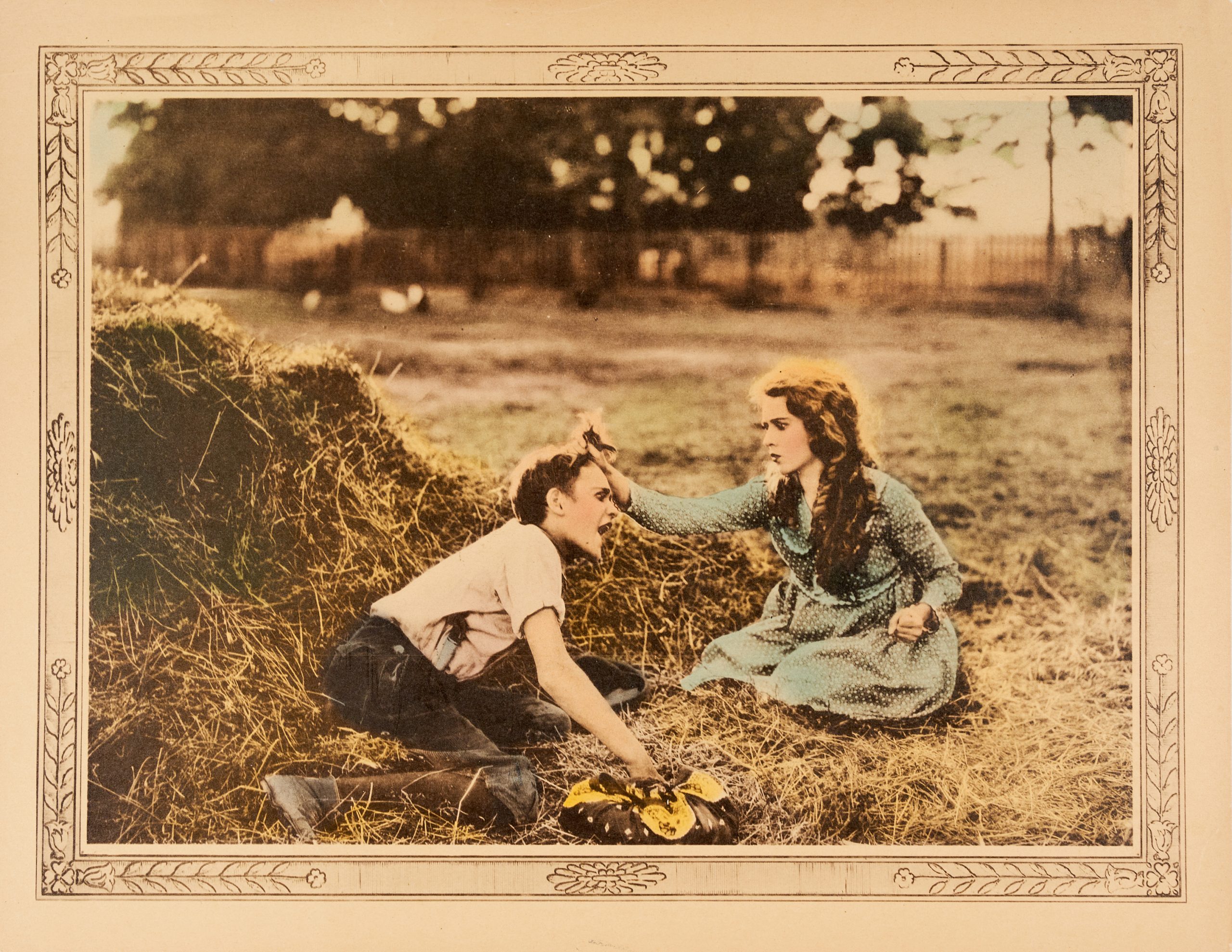 A colored-in lobby card featuring a group of girls and a woman bathing a young boy outside.