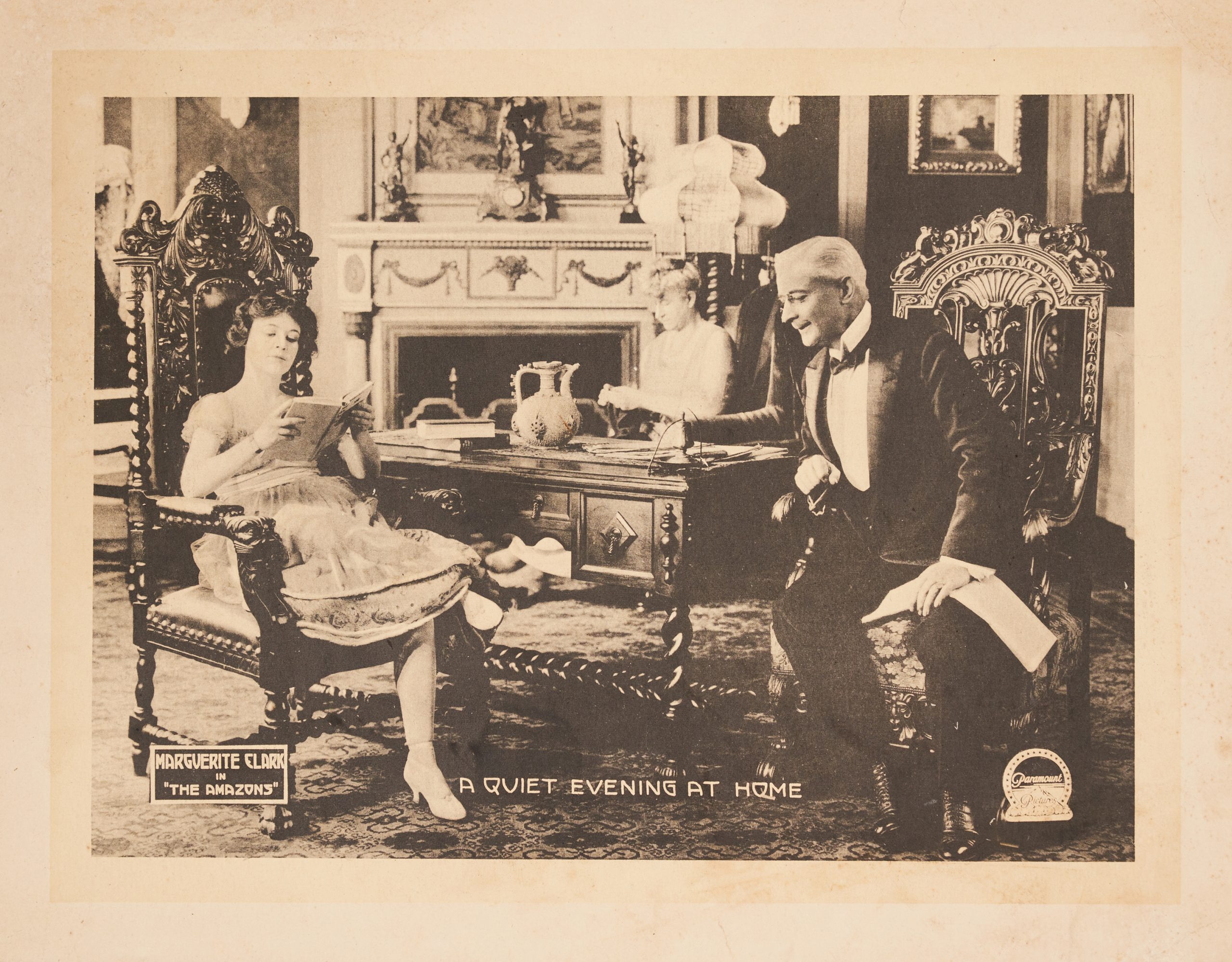 Lobby card with an older man staring at the legs of a younger woman who has them crossed at the knee.