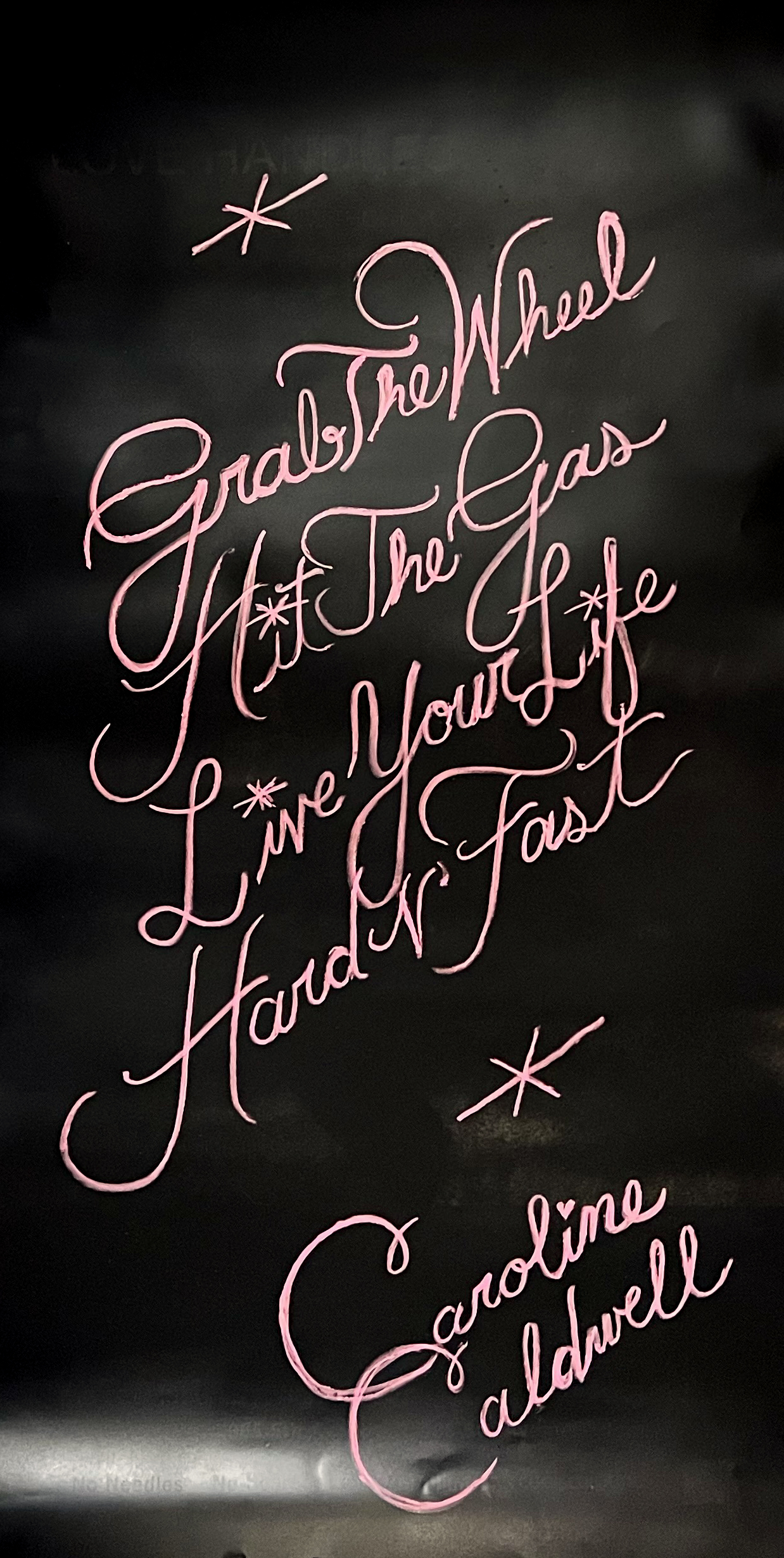 A spray painted poster depicting pink script on a black background.