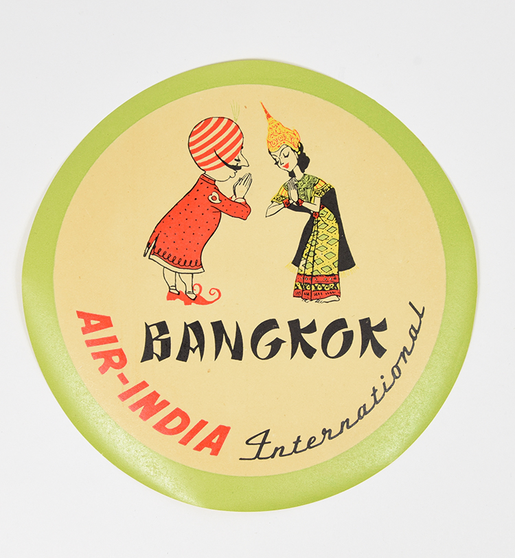 A coaster of a mustachiod figure wearing a turban bowing to a person from Bangkok who bows back.